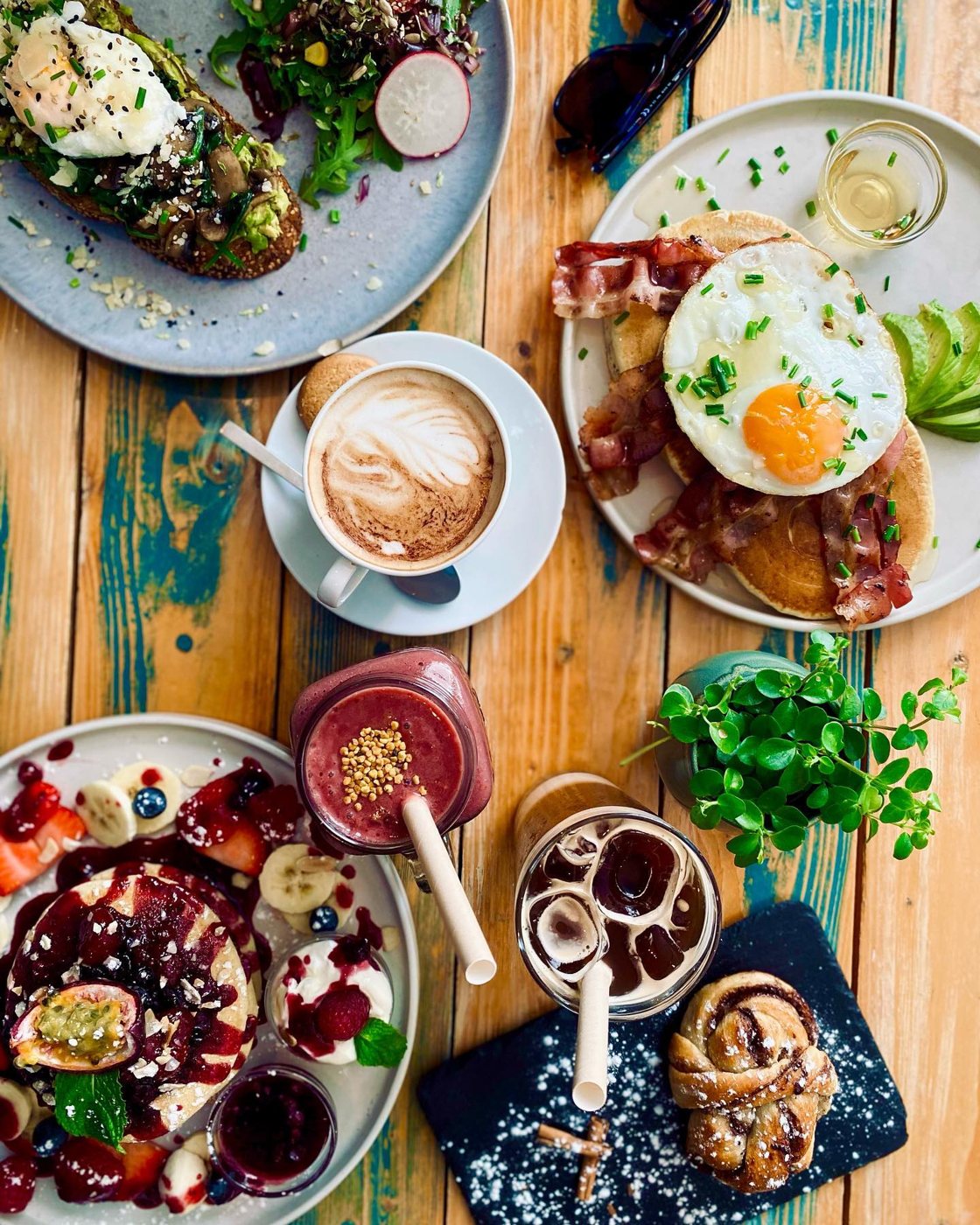Mesa de brunch do Goji com ovos, tostas, panquecas, açaí e café